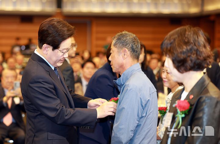 [서울=뉴시스] 고범준 기자 = 이재명 대통령이 8일 서울 중구 대한상공회의소에서 열린 제54회 어버이날 기념식에서 순직 공무원 부모님께 카네이션을 달아주고 있다. 2026.05.08. bjko@newsis.com