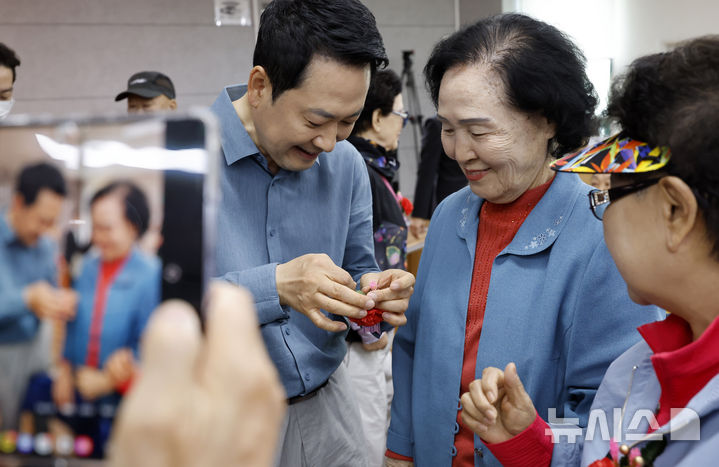 [서울=뉴시스] 김혜진 기자 = 장동혁 국민의힘 당대표가 8일 서울 양천구 목동종합사회복지관에서 열린 어버이날 기념 '사랑해효 감사잔치'에 참석해 한 어르신께 카네이션을 달아드리고 있다. 2026.05.08. jini@newsis.com
