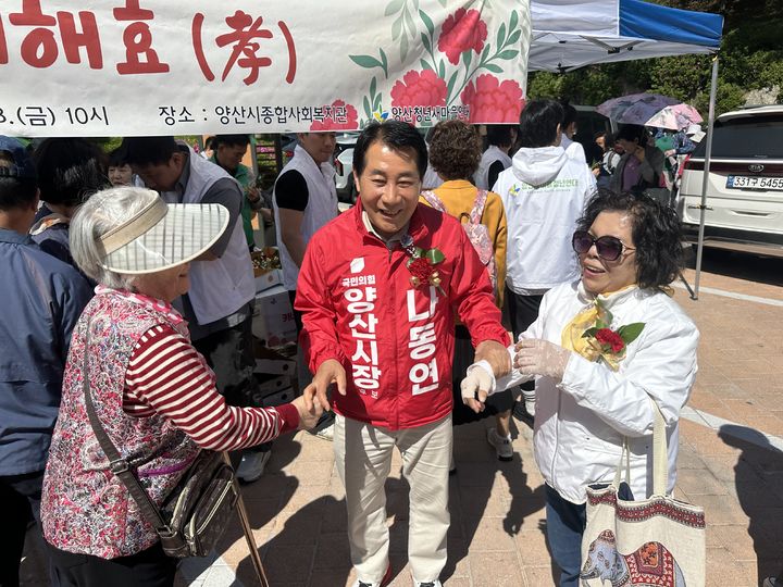 [양산=뉴시스] 국민의힘 나동연 경남 양산시장 후보가 8일 어버이날 행사장을 방문해 어르신들의 손을 맞잡고 따뜻한 대화를 나누고 있다. (사진=나동연 선거사무실 제공) 2026.05.09. photo@newsis.com *재판매 및 DB 금지