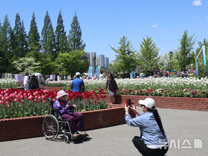 [서울=뉴시스]고희진 인턴기자=8일 고양시 일산호수공원에 마련된 튤립 정원 앞에서 딸이 어머니의 사진을 찍어주고 있다.