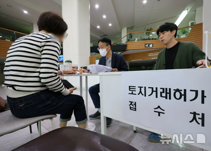 [서울=뉴시스] 배훈식 기자 = 다주택자 양도 소득세 중과 면제 종료일인 9일 오후 서울 송파구청 1층 로비에 마련된 토지거래허가 접수처를 찾은 한 시민이 부동산정보과 담당자와 상담하고 있다.  국토교통부가 이날 오후 6시까지 관련 서류를 제출하고 최대 11월까지 양도 절차를 마무리하면 양도세 중과를 면제키로 하면서 서울 25개 구청이 휴일임에도 문을 열었다 2026.05.09. dahora83@newsis.com