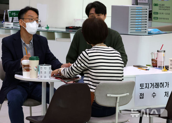 [서울=뉴시스] 배훈식 기자 = 다주택자 양도 소득세 중과 면제 종료일인 9일 오후 서울 송파구청 1층 로비에 마련된 토지거래허가 접수처를 찾은 한 시민이 부동산정보과 담당자와 상담하고 있다.  국토교통부가 이날 오후 6시까지 관련 서류를 제출하고 최대 11월까지 양도 절차를 마무리하면 양도세 중과를 면제키로 하면서 서울 25개 구청이 휴일임에도 문을 열었다 2026.05.09. dahora83@newsis.com
