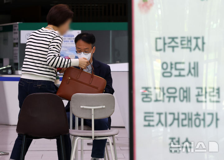 [서울=뉴시스] 배훈식 기자 = 다주택자 양도 소득세 중과 면제 종료일인 9일 오후 서울 송파구청 1층 로비에 마련된 토지거래허가 접수처를 찾은 한 시민이 부동산정보과 담당자와 상담하고 있다.  국토교통부가 이날 오후 6시까지 관련 서류를 제출하고 최대 11월까지 양도 절차를 마무리하면 양도세 중과를 면제키로 하면서 서울 25개 구청이 휴일임에도 문을 열었다 2026.05.09. dahora83@newsis.com