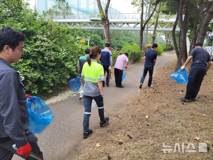 [시흥=뉴시스] 시흥스마트허브 입주 일부 기업의 근로자들이 집게 등을 들고 '2026 아름다운 산업단지 가꾸기' 활동에 참여하고 있다.(사진=시흥시 제공).2026.05.10. photo@newsis.com 