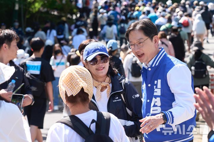[창원=뉴시스]더불어민주당 김경수 경남도지사 후보가 10일 오전 창원시 진해구에서 진행된 제16회 진해만 생태숲 걷기대회에 참석해 참가자들과 인사를 나누고 있다.(사진=김경수후보 선거사무소 제공) 2026.05.10. photo@newsis.com