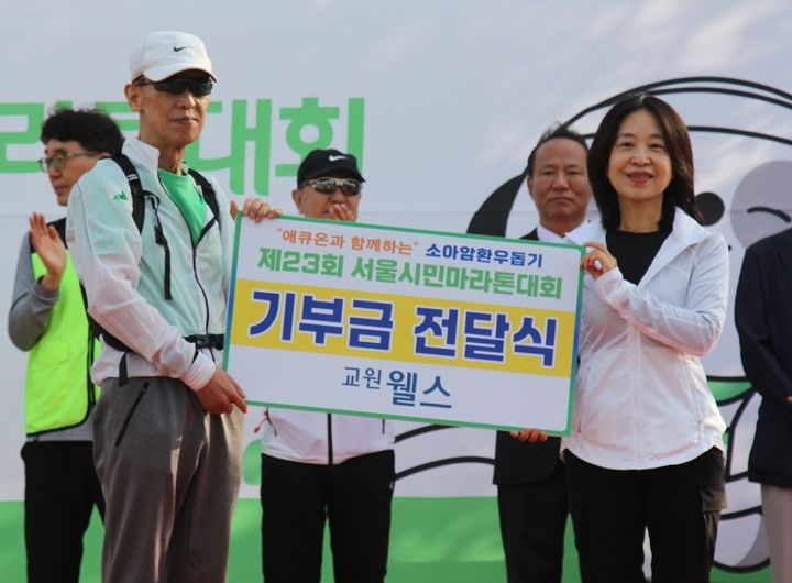 [서울=뉴시스] 송현주(오른쪽) 교원 웰스 상품전략 부문장이 이동윤 소아암환우돕기조직위원회 대회장에게 지난 10일 기부금을 전달하고 기념촬영을 하고 있다. (사진=교원 웰스 제공) 2026.05.11. photo@newsis.com *재판매 및 DB 금지