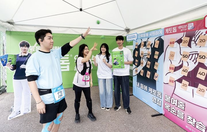 [서울=뉴시스] ‘2026 나는 솔로런’ 마라톤 행사에서 마련된 한독 케토톱 액티브 쿨 체험부스에서 참가자들이 ‘내 등에 케토톱 붙여줄 영철과 옥순을 찾아요’ 콘셉트의 공감형 게임을 즐기고 있다. (사진=한독 제공) 2026.5.11. photo@newsis.com *재판매 및 DB 금지