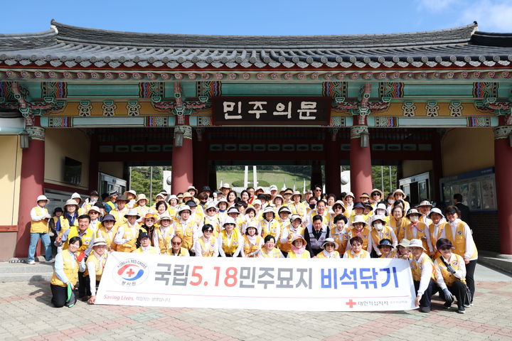 [광주=뉴시스] 적십자사 광주전남지사 관계자들이 11일 광주 북구 운정동 국립5·18민주묘지에서 비석 닦기와 조화 교체 등 환경정비 봉사활동을 진행한 후 기념촬영을 하고 있다. (사진=적십자사 광주전남지사 제공) 2026.05.11. photo@newsis.com *재판매 및 DB 금지