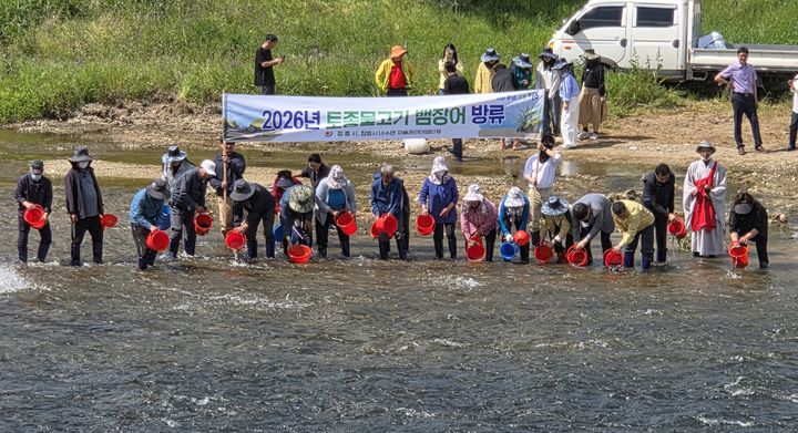 [정읍=뉴시스]11일 정읍 동진천 생태복원을 위해 모인 칠보면민과 수산업경영인 정읍시연합회원, 명암사 주지 스님 및 신도 등이 어린 뱀장어 3만 마리를 하천에 방류하고 있다. *재판매 및 DB 금지