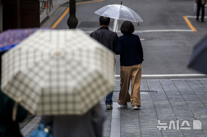 [서울=뉴시스] 정병혁 기자 = 전날(11일) 서울 중구 남산골한옥마을을 찾은 관광객들이 우산을 쓴 채 이동하고 있다. 2026.05.12. jhope@newsis.com