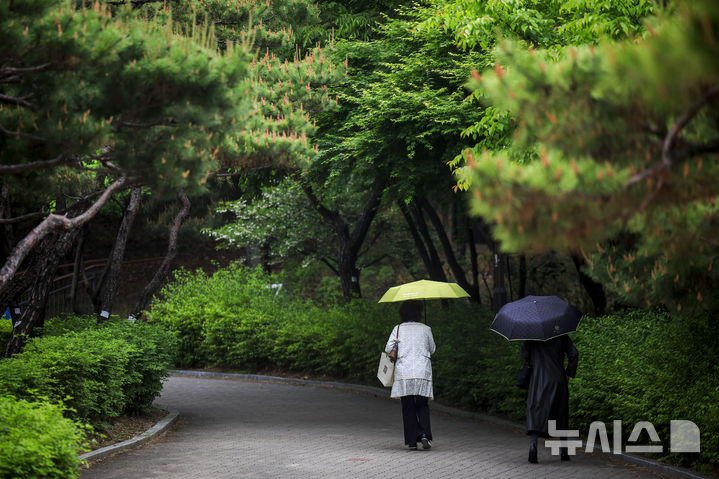 [서울=뉴시스] 정병혁 기자 = 11일 서울 중구 남산골한옥마을을 찾은 관광객들이 우산을 쓴 채 이동하고 있다. 2026.05.11. jhope@newsis.com