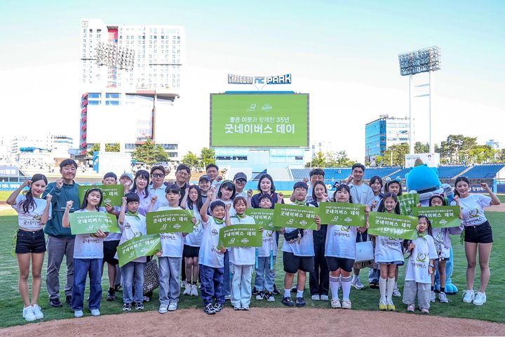 [서울=뉴시스] 글로벌 아동권리 전문 비정부기구(NGO) 굿네이버스는 어린이날 주간을 맞아 5월 9일부터 이틀간 창원NC파크에서 진행한 '굿네이버스 데이'를 성황리에 마무리했다고 12일 밝혔다. 사진은 지난 10일 경기 종료 후 그라운드에서 기념사진을 촬영하고 있는 지난해 희망편지쓰기대회 수상 아동과 가족들의 모습. (사진=굿네이버스 제공) 2026.05.12. photo@newsis.com *재판매 및 DB 금지