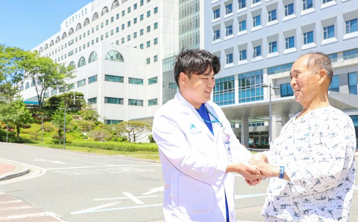 [강릉=뉴시스] 최돈기씨가 강릉아산병원 김세훈 방사선사의 손을 잡고 감사 인사를 전하고 있다.(사진=강릉아산병원 제공)photo@newsis.com *재판매 및 DB 금지