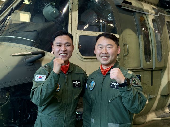 [영천=뉴시스] 정재익 기자 = 12일 경북 영천 육군 제2작전사령부 21항공단 헬기 정비소에서 석경태 207항공대대 소령(왼쪽)과  박성훈 준위가 수리온(KUH-1) 산불진화헬기 앞에서 포즈를 취하고 있다. 2026.05.12. jjikk@newsis.com *재판매 및 DB 금지