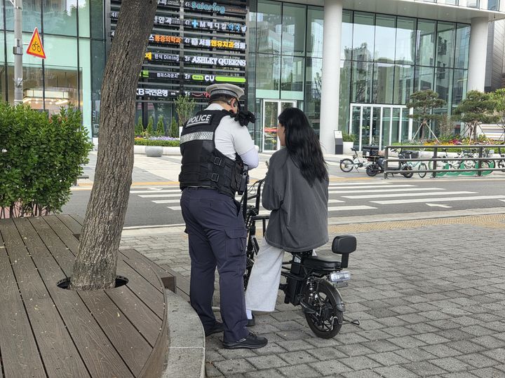 [서울=뉴시스] 이지영 기자= 12일 오후 서울 동대문구 장안동사거리 인근에서 범칙금을 부과하는 경찰. 2026.05.12 jee0@newsis.com *재판매 및 DB 금지