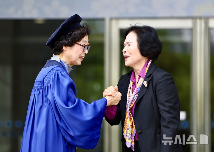 [서울=뉴시스] 김명년 기자 = 12일 오전 서울 용산구 숙명여자대학교 백주년기념관에서 열린 '졸업 50주년 홈커밍데이' 행사에서 학위복을 입은 50여년 전 졸업생이 동문과 인사하고 있다. 2026.05.12. kmn@newsis.com