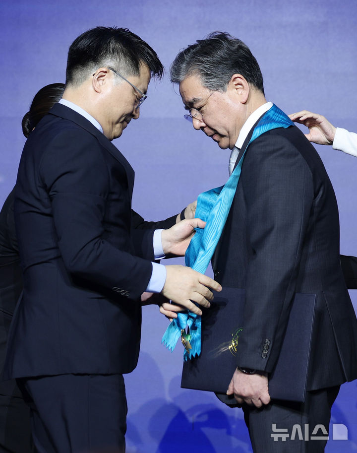 [서울=뉴시스] 김진아 기자 = 장재훈(오른쪽) 현대자동차그룹 부회장이 12일 서울 서초구 JW메리어트호텔에서 열린 제23회 자동차의 날 기념식에서 문신학 산업통상부 1차관으로부터 금탑산업훈장을 수여받고 있다. 2026.05.12. bluesoda@newsis.com