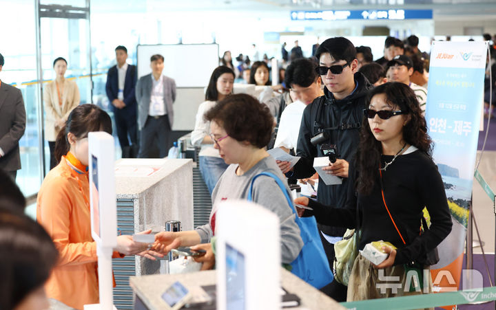 [인천공항=뉴시스] 전신 기자 = 인천-제주 국내선 직항노선이 10년 만에 운항을 재개한 12일 인천국제공항 제1여객터미널에서 제주행 항공편 탑승객들이 티켓을 확인 받고 있다. 2026.05.12. photo1006@newsis.com