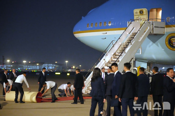 [베이징=AP/뉴시스] 도널드 트럼프 미국 대통령이 13일(현지 시간) 중국 베이징 수도 국제공항에 도착하자 중국 관계자들이 레드카펫을 펼치고 있다. 2026.05.14.