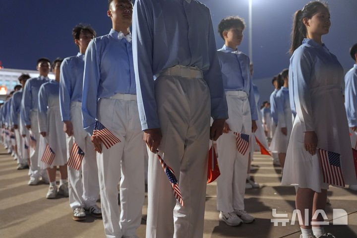 [베이징=AP/뉴시스] 도널드 트럼프 미국 대통령이 13일(현지 시간) 중국 베이징 수도 국제공항에 도착하자 중국 어린이들이 양국 국기를 들고 서 있다. 2026.05.14.
