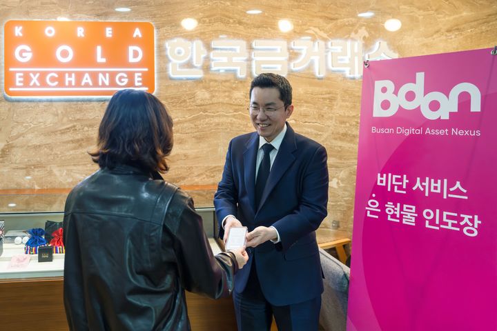 [부산=뉴시스] 김상민 부산디지털자산거래소 비단(Bdan) 대표가 실물교환을 신청한 고객에게 실버바를 인도하고 있다. (사진=부산디지털자산거래소 제공) 2026.05.13. photo@newsis.com *재판매 및 DB 금지