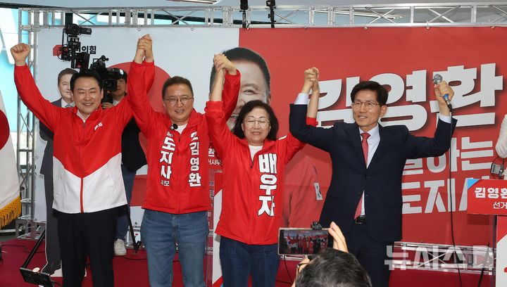 [청주=뉴시스] 서주영 기자 = 13일 충북 청주시 흥덕구 복대동에서 열린 김영환 국민의힘 충북지사 예비후보 선거사무소 개소식에서 장동혁 대표가 김 후보와 손을 맞잡고 기념촬영을 하고 있다. 2026.05.13. juyeong@newsis.com