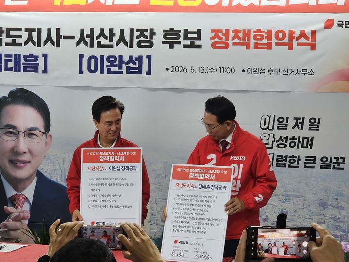 [서산=뉴시스] 김덕진 기자=김태흠(왼쪽) 충남도지사 후보와 이완섭 서산시장 후보가 13일 이 시장 후보 선거사무실을 찾아 정책협약을 맺은 후 공동정책이 담긴 손팻말을 들고 기념 사진을 찍고 있다. 2026.05.13. spark@newsis.com *재판매 및 DB 금지