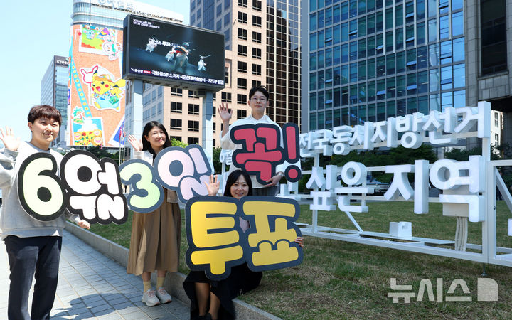 [서울=뉴시스] 전신 기자 = 13일 서울 중구 프레스센터 인근에 설치된 제9회 전국동시지방선거 홍보 조형물 앞에서 서울시선관위 직원들이 투표 참여를 독려하고 있다. 2026.05.13. photo1006@newsis.com