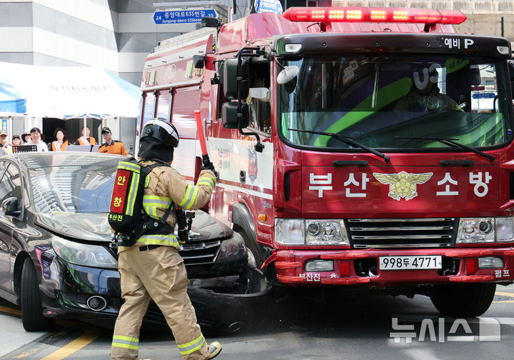  [부산=뉴시스] 하경민 기자 = 부산소방재난본부 긴급출동 통행 방해 불법 주·정차 차량 강제처분 훈련이 열린 13일 부산 부산진구 범천동의 한 이면도로에서 소방차량이 출동로 확보를 위해 주차차량을 강제로 돌파하고 있다. 2026.05.13. yulnetphoto@newsis.com