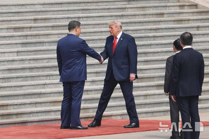 [베이징=AP/뉴시스] 시진핑(왼쪽) 중국 국가주석이 14일(현지 시간) 중국 베이징 인민대회당에서 열린 공식 환영 행사에서 도널드 트럼프 미국 대통령과 악수하고 있다. 2026.05.14.