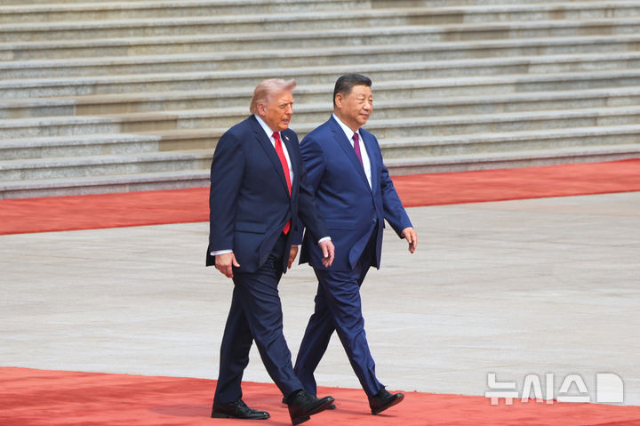 [베이징=AP/뉴시스] 시진핑(오른쪽) 중국 국가주석이 14일(현지 시간) 중국 베이징 인민대회당에서 열린 공식 환영 행사에서 도널드 트럼프 미국 대통령과 나란히 걸어가고 있다. 2026.05.14.