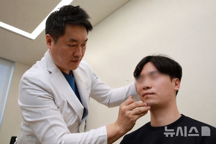 [서울=뉴시스] 자생한방병원 의료진이 안면신경마비 환자에게 침 치료를 하고 있다. (사진= 자생한방병원 제공)
