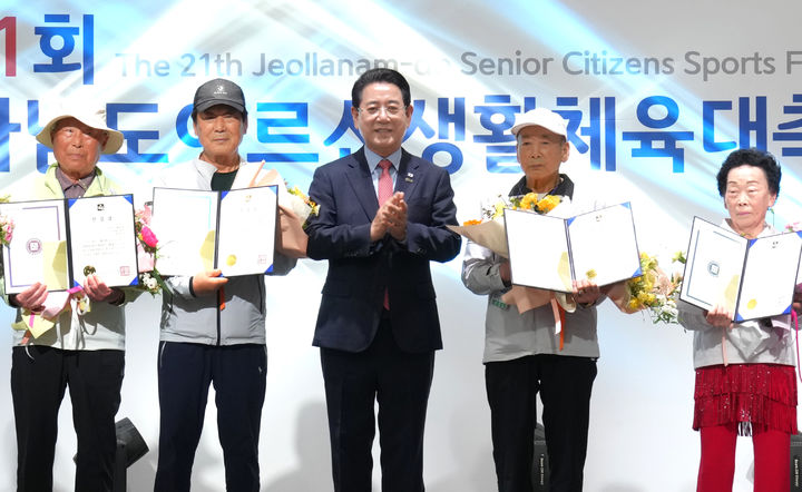 [장성=뉴시스] 김영록 전남지사가 14일 장성 홍길동체육관에서 열린 제21회 전남도어르신생활체육대축전 개회식에 참석, 경기 종목별 최고령자에게 건강상을 수여한 뒤 기념촬영을 하고 있다. (사진 = 전남도 제공). 2026.05.14. photo@newsis.com *재판매 및 DB 금지