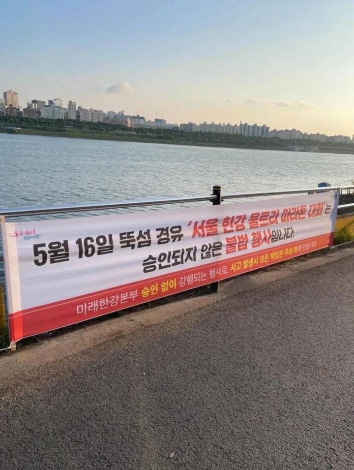 [서울=뉴시스] 한강공원 산책로에 설치된 현수막에 '미래한강본부의 승인 없이 강행되는 불법 행사'라는 문구와 함께 사고 발생 시 모든 책임이 주최 측에 있다는 경고문이 적혀 있다. (사진 출처=엑스 캡처)