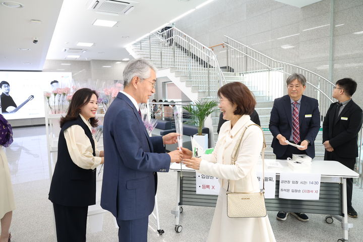 [창원=뉴시스]14일 진주 경상남도교육청 예술교육원 해봄아트홀에서 박종훈 교육감이 스승의 날 기념 '봄날 콘서트'에 앞서 교사에게 카네이션을 건네주는 모습.(사진=경남교육청 제공) 2026.05.14.photo@newsis.com *재판매 및 DB 금지
