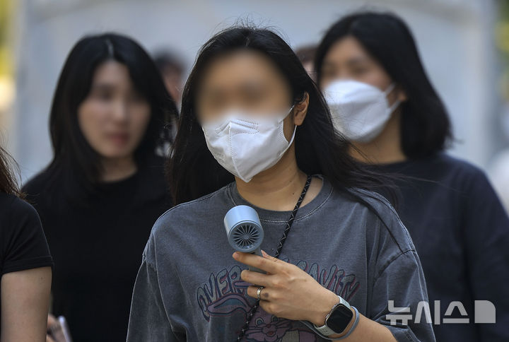 [서울=뉴시스] 정병혁 기자 = 낮 기온이 30도 안팎으로 올라 더운 날씨를 보인 14일 서울 중구 청계천에서 손선풍기를 든 시민이 이동하고 있다. 2026.05.14. jhope@newsis.com