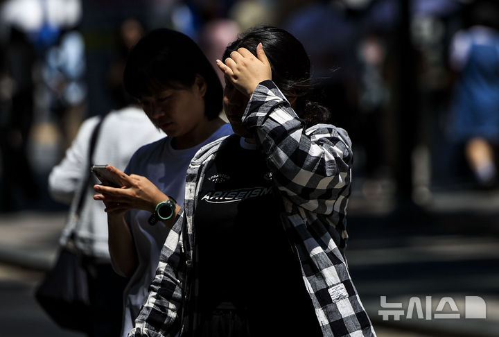 [서울=뉴시스] 정병혁 기자 = 낮 기온이 30도 안팎으로 올라 더운 날씨를 보인 14일 서울 중구 시청역 인근에서 한 시민이 손으로 햇빛을 가린 채 이동하고 있다. 2026.05.14. jhope@newsis.com **위 사진은 기사 내용과 직접적인 관련이 없음