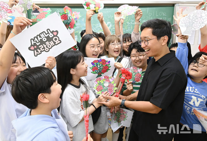 [수원=뉴시스] 김종택기자 = 스승의 날을 하루 앞둔 14일 경기 수원시 영통구 효동초등학교에서 학생들이 담임 선생님에게 감사의 인사를 전하고 있다. 2026.05.14. jtk@newsis.com