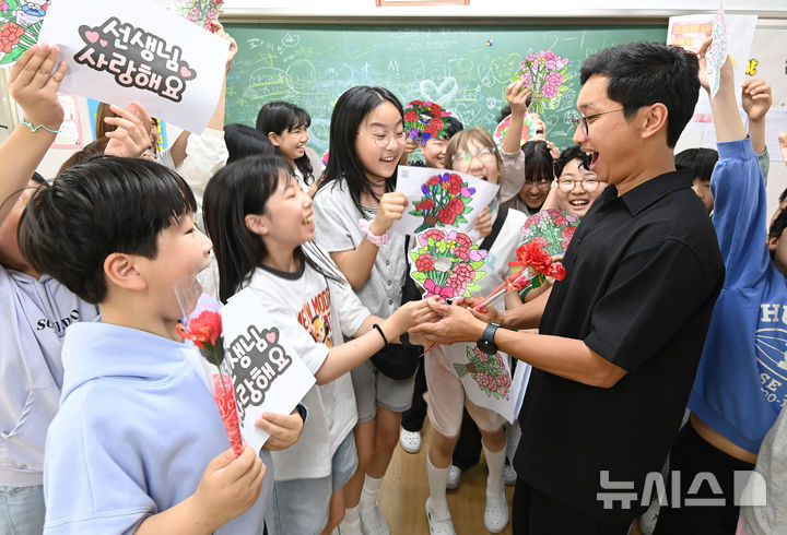 [수원=뉴시스] 김종택기자 = 스승의 날을 하루 앞둔 14일 경기 수원시 영통구 효동초등학교에서 학생들이 담임 선생님에게 감사의 인사를 전하고 있다. 2026.05.14. jtk@newsis.com