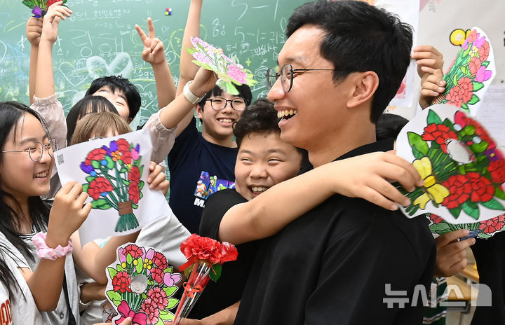 [수원=뉴시스] 김종택기자 = 스승의 날을 하루 앞둔 14일 경기 수원시 영통구 효동초등학교에서 학생들이 담임 선생님에게 감사의 인사를 전하고 있다. 2026.05.14. jtk@newsis.com