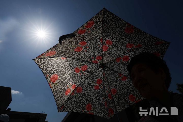 [서울=뉴시스] 김명년 기자 = 초여름 날씨를 보인 14일 오후 서울 종로구 광화문광장에서 시민이 양산을 쓰고 이동하고 있다. 2026.05.14. kmn@newsis.com