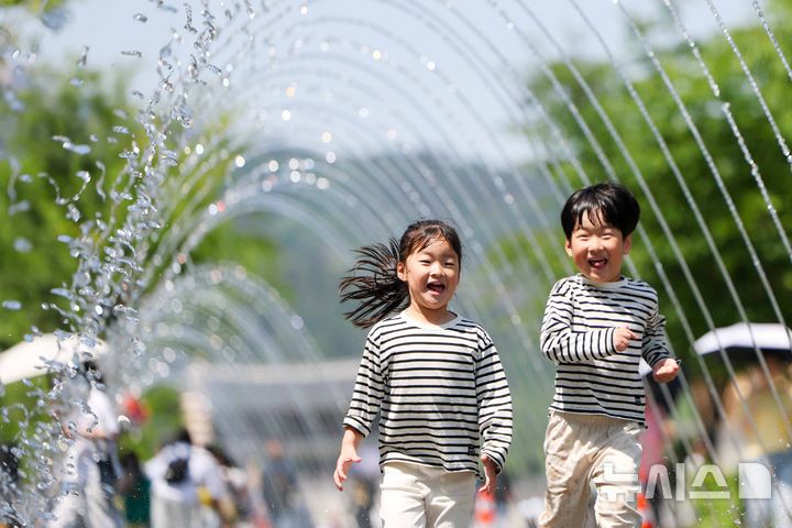 [서울=뉴시스] 김명년 기자 = 초여름 날씨를 보인 14일 오후 서울 종로구 광화문광장 분수대 터널에서 아이들이 물놀이를 하며 더위를 식히고 있다. 2026.05.14. kmn@newsis.com