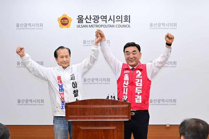 [울산=뉴시스] 무소속 이철수 울산시장 예비후보(왼쪽)가 15일 울산시의회 프레스센터에서 후보직을 사퇴하고 국민의힘 김두겸 후보를 지지한다는 입장을 밝힌 뒤 김두겸 후보와 손을 잡고 기념촬영을 하고 있다. (사진=울산시의회 제공) 2026.05.15. photo@newsis.com *재판매 및 DB 금지