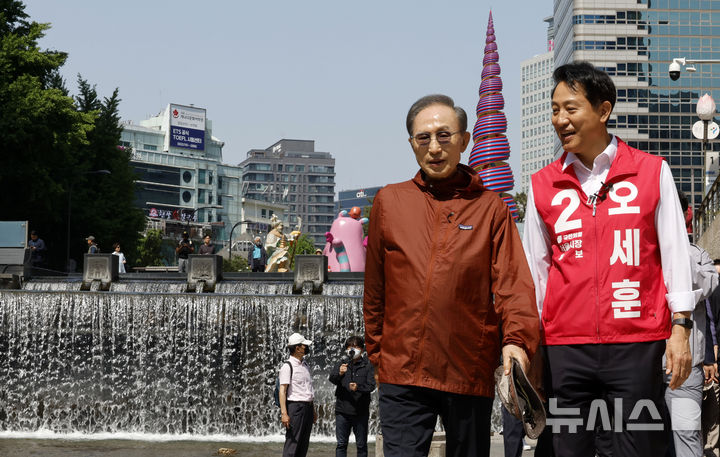 [서울=뉴시스] 김혜진 기자 = 오세훈 국민의힘 서울시장 후보가 15일 서울 중구 청계천에서 이명박 전 대통령과 만나 지지자들을 향해 인사를 하고 있다. 2026.05.15. jini@newsis.com