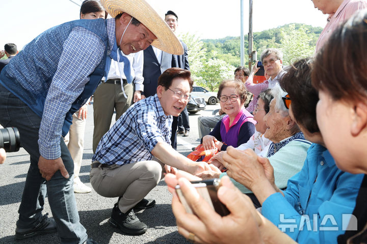 [대구=뉴시스] 최동준 기자 = 이재명 대통령이 15일 대구 군위군 소보면 마을 일원에서 모내기 작업 전 주민들과 인사하고 있다. (청와대통신사진기자단) 2026.05.15. photocdj@newsis.com