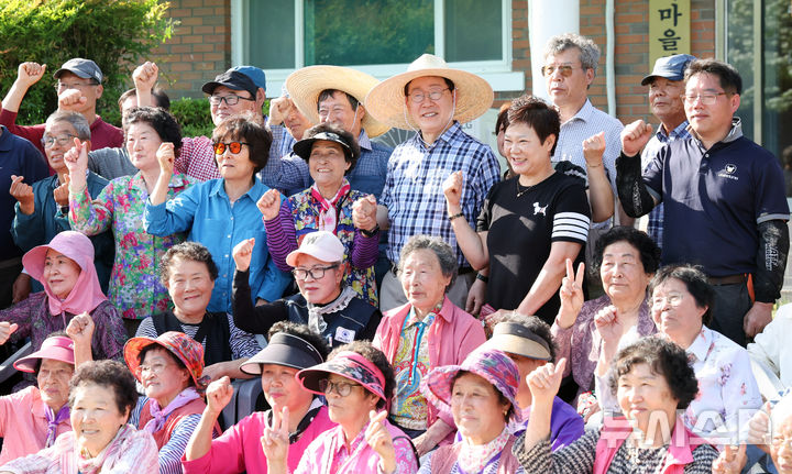 [대구=뉴시스] 최동준 기자 = 이재명 대통령이 15일 대구 군위군 소보면 마을 일원에서 모내기 작업을 마친 뒤 주민들과 기념촬영을 하고 있다. (청와대통신사진기자단) 2026.05.15. photocdj@newsis.com