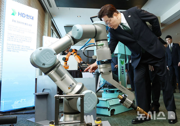 [울산=뉴시스] 고범준 기자 = 이재명 대통령이 13일 울산 동구 호텔현대 바이 라한 울산에서 열린 K-조선 미래비전 간담회를 마치고 HD현대 조립 크레인형 용접 로봇을 살펴보고 있다. (청와대통신사진기자단) 2026.05.13. bjko@newsis.com