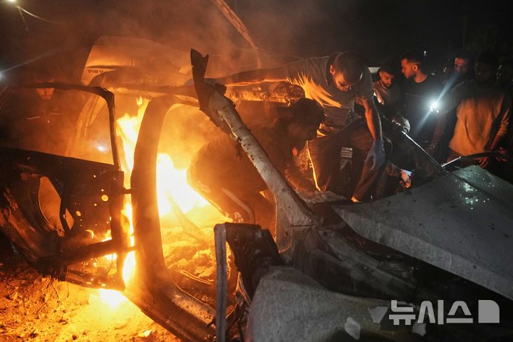 [가자시티=AP/뉴시스] 15일(현지시간) 가자지구 가자시티 리말 주거 지역에서 주민들이 이스라엘군의 공습으로 파괴된 자동차 내부를 수색하고 있다. 이스라엘은 하마스 최고 군사 지도자 이즈 알딘 알하다드를 표적으로 가자시티를 공습했다고 밝혔다. 2026.05.16