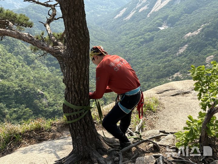 [서울=뉴시스]신유림 기자=15일 오후 출동 지령을 받은 북한산 산악구조대 이호진(31) 소방교가 노적봉 하단 인근 암벽 구간에서 내려갈 준비를 하고 있다. 2026.05.15. spicy@newsis.com