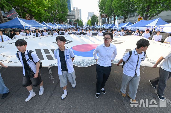 [광주=뉴시스] 이영주 기자 = 5·18민주화운동 46주기를 이틀 앞둔 16일 오후 광주 동구 금남로에서 5·18민중항쟁기념행사위원회의 민주평화대행진 행사에 참여한 광주지역 학생들이 대형 태극기를 들고 행진하고 있다. 2026.05.16.leeyj2578@newsis.com